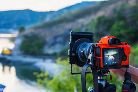 Mirrorless camera on a tripod with sunset landscape Stock Photos