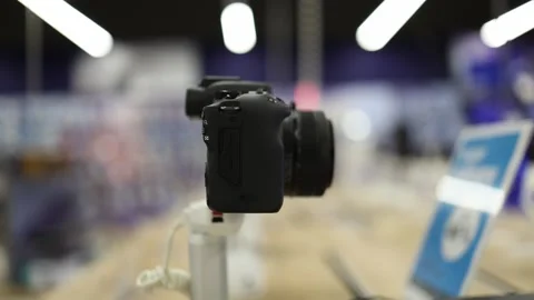 Mirrorless digital camera with lens displayed inside electronics store Stock Footage 345358945
