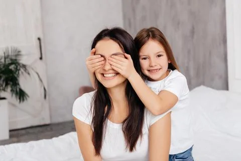 Mirthful girl having fun with her mother Stock Photos