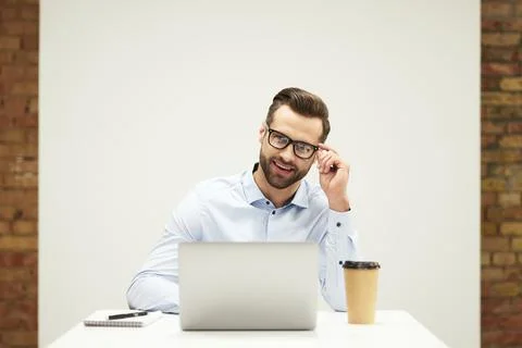 Mirthful man looking at the screen with contented smile Stock Photos