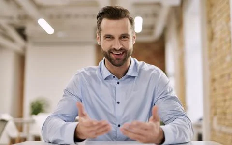 Mirthful office manager gesturing while talking at work Stock Photos
