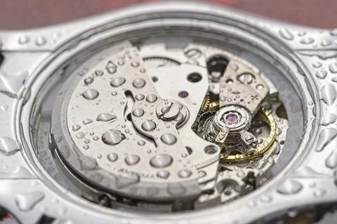 Misaligned spring and speed adjustment of a mechanical watch with water drops Stock Photos