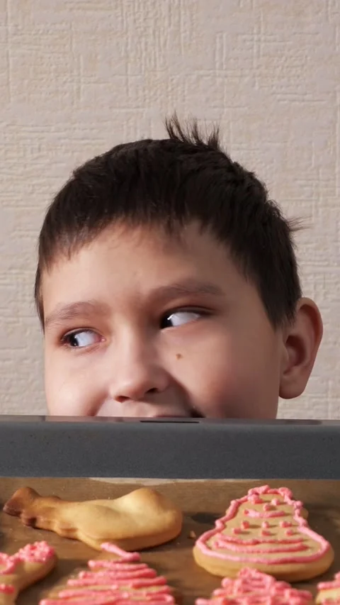 Mischievous boy secretly stealing a freshly baked christmas cookie from a baking Stock Footage 342905617