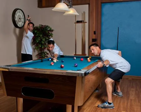 Mischievous triplets playing billiards Stock Photos