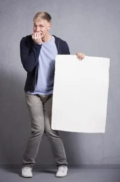 Miserable man holding white empty signboard. Foto stock