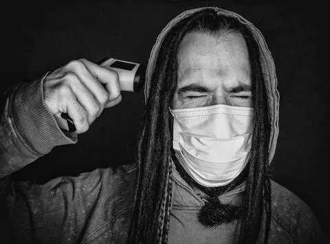 Miserable man with thermometer gun Stock Photos