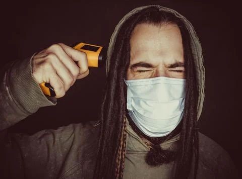 Miserable man with thermometer gun Stock Photos