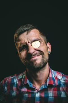 A miserly man with a bitcoin instead of an eye Stock Photos