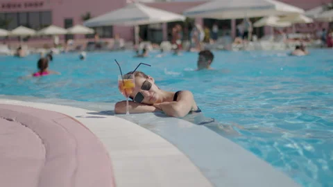 Miss with sunglasses drinks a cocktail while in the pool. woman enjoying summer Stock Footage 200979835