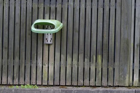Missing bin lid on old dirty wooden fence Stock Photos