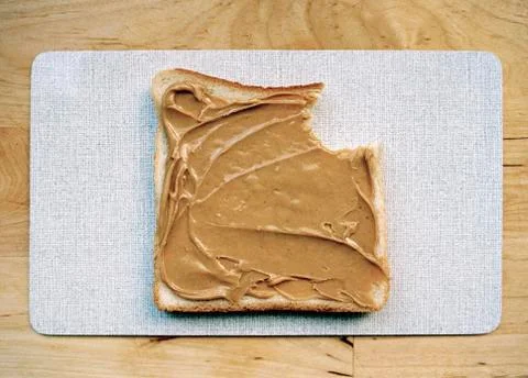 A missing bite from a slice of bread with peanut butter Foto stock