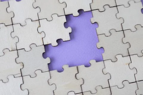 Missing heart-shaped puzzles. A background of puzzles with a light purple empty Stock Photos