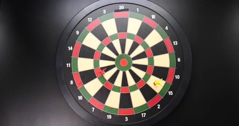 Missing the mark darts hitting board but not the bullseye isolated on black Stock Footage 205429974