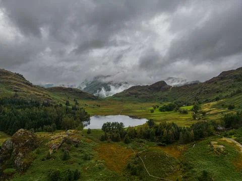 Mist and low cloud envelop the Langdale hills with Blea Tarn in the foregroun Stock Photos