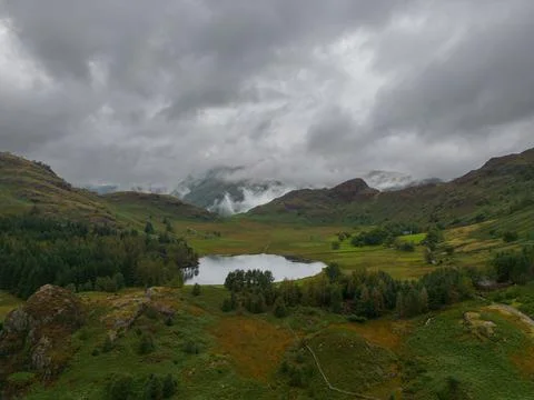 Mist and low cloud envelop the Langdale hills with Blea Tarn in the foregroun Stock Photos