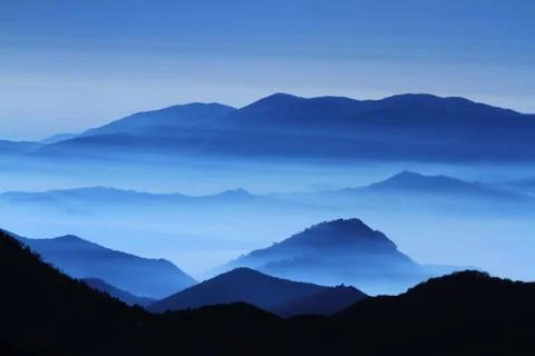 Mist between the mountain peaks Stock Photos