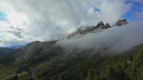 Mist-covered peaks and winding road, morning fog drifts through valley; mountain Vídeo Stock 323980372