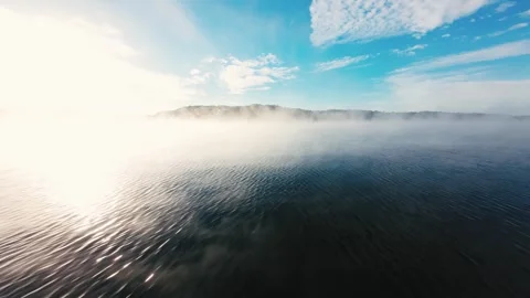 Mist drifts over calm, deep waters under soft morning light Stock Footage 340904569