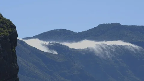 Mist falling over the ridge of a mountain into the valley Stock Footage 86465944