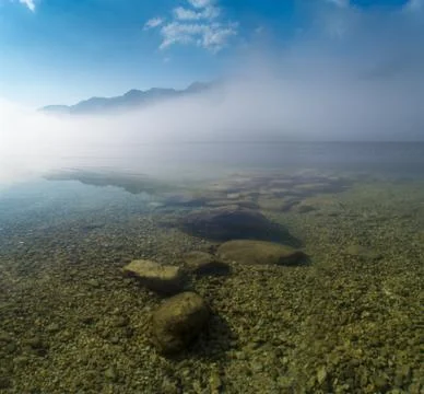 Mist hovering over alpine lake Stock Photos