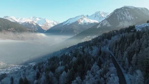 Mist Lingers Over Snow-Dusted Alpine Forests Beneath Majestic Peaks Vídeos de archivo 334280280