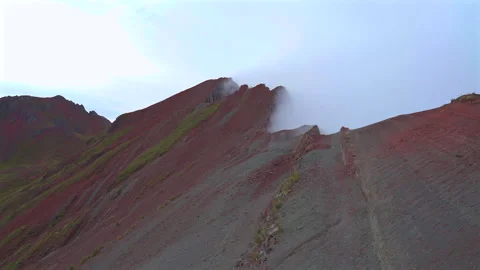 Mist moving over the sharp red ridge of Pallay Punchu mountain in Cusco Peru Stock Footage 345395025