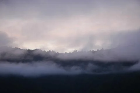 Mist over a mountain range at sunset Stock Photos