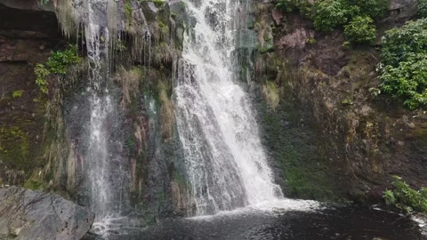 Mist rises from cascading water against mossy rock faces Vidéo 342927350