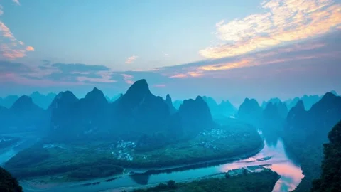 Mist rises over karst mountains beside a winding river Stock Footage 333814808