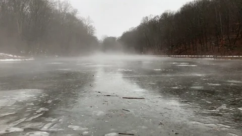Mist Rolling Over Icy Pond During Dreary Winter Rainstorm Stock Footage 85282638