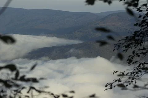 Mist rolls over a mountain range in the early morning light illuminating th.. Stock Photos