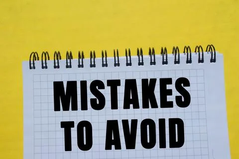 Mistakes to avoid message written on notebook page on yellow background. Co.. Foto stock
