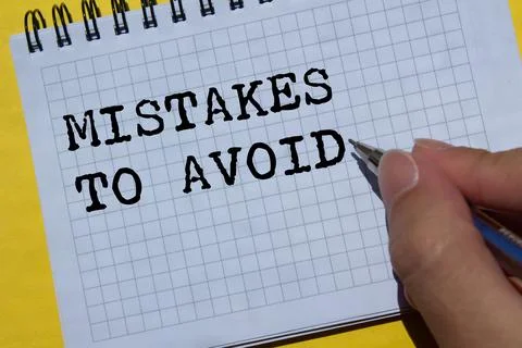 Mistakes to avoid message written on notebook page on yellow background. Co.. Foto stock