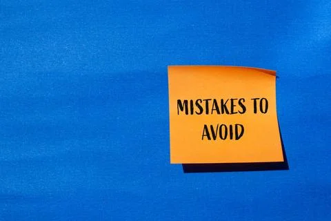 Mistakes to avoid message written on orange paper with blue background. Conce Foto stock