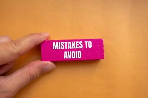 Mistakes to avoid message written on pink wooden block with orange backgrou.. Foto stock