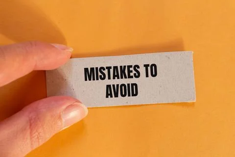 Mistakes to avoid message written on ripped paper piece with orange backgroun Foto stock
