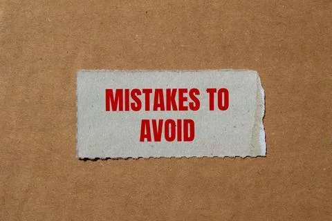 Mistakes to avoid message written on ripped paper piece with cardboard backgr 写真素材