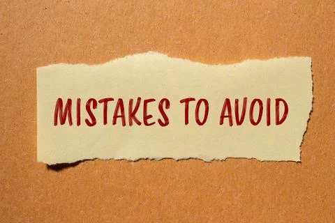 Mistakes to avoid message written on ripped paper piece with cardboard backgr 写真素材