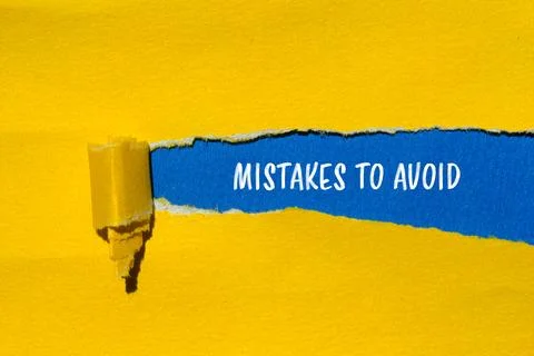 Mistakes to avoid message written on ripped yellow paper with blue background 写真素材