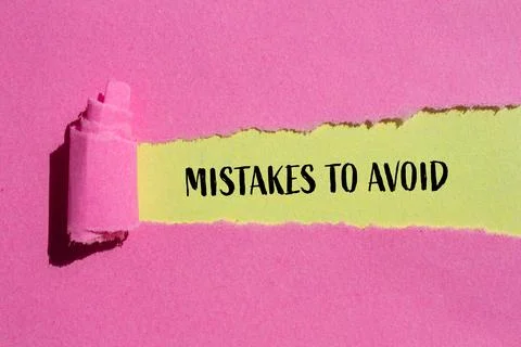 Mistakes to avoid message written on ripped pink paper with yellow background 写真素材