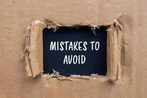 Mistakes to avoid message written on ripped cardboard paper with black backgr Foto stock