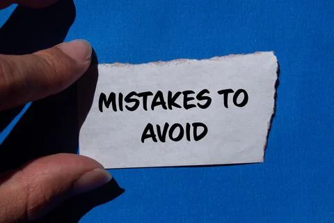 Mistakes to avoid message written on ripped torn paper with blue background.  Stockfoto's