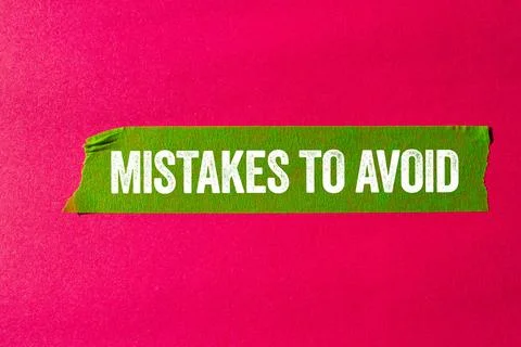 Mistakes to avoid message written on ripped torn green paper tape on pink b.. Foto stock