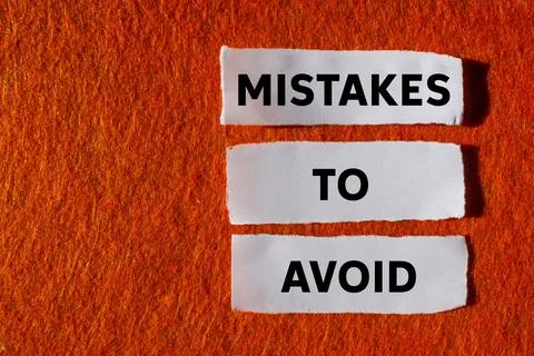Mistakes to avoid message written on ripped torn white paper pieces on oran.. 库存照片