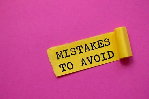 Mistakes to avoid message written on ripped torn yellow paper piece on pink.. 写真素材