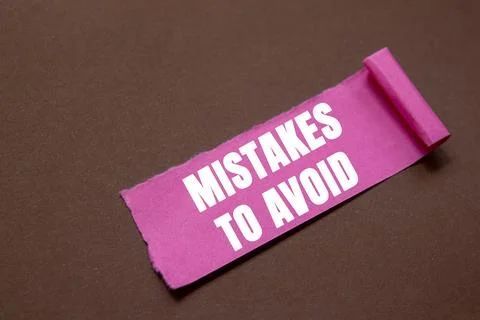 Mistakes to avoid message written on ripped torn pink paper piece on brown .. 写真素材
