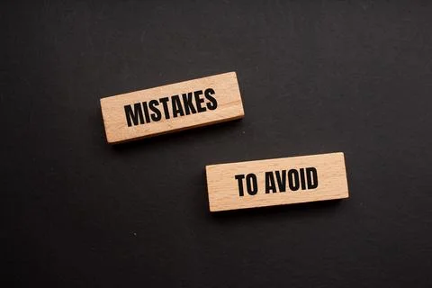 Mistakes to avoid message written on wooden blocks with black background. Con Foto stock