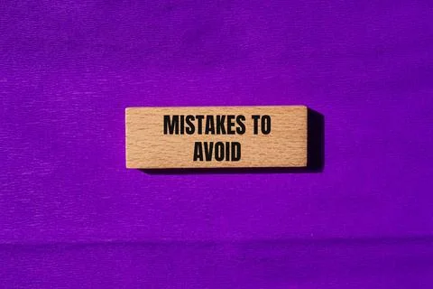 Mistakes to avoid message written on wooden blocks with purple background. Co Foto stock
