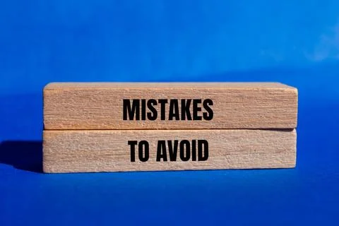 Mistakes to avoid  message written on wooden blocks with blue background. Con Foto stock