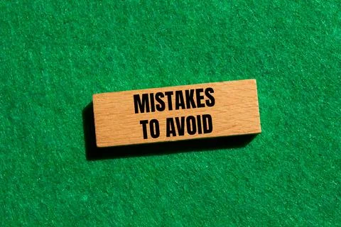 Mistakes to avoid message written on wooden block with green background. Co.. Foto stock